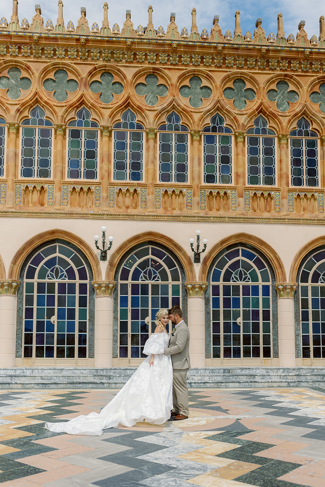 Key West wedding with groom holding his brides waist outside of the Ringling Museum in a courtyard