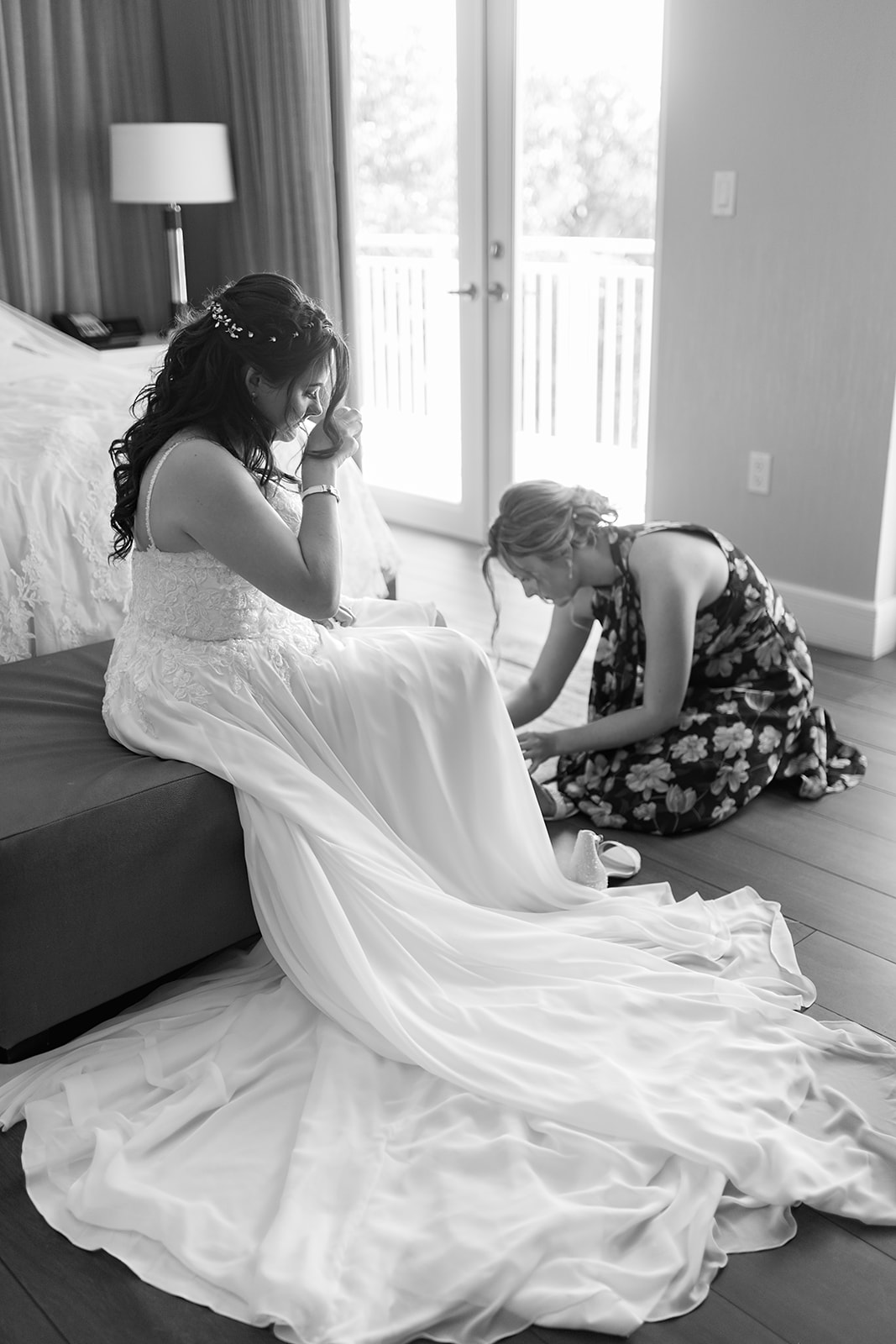 maid of honor helping the bride put on her wedding heels in the bridal suite of key west wedding venues